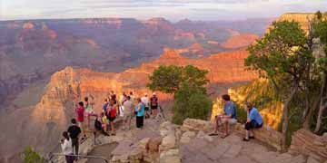 People standing on rocks looking at the Grand Canyon